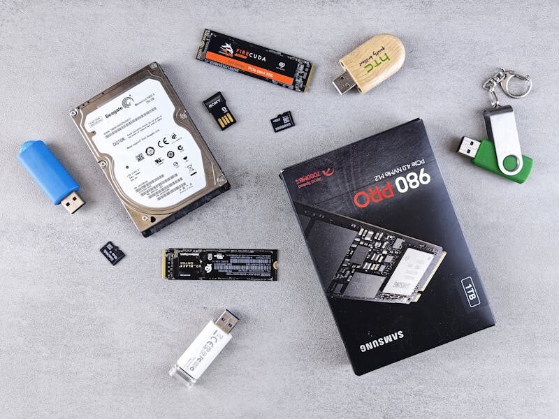 Flat lay of various computer data storage devices on a gray surface.